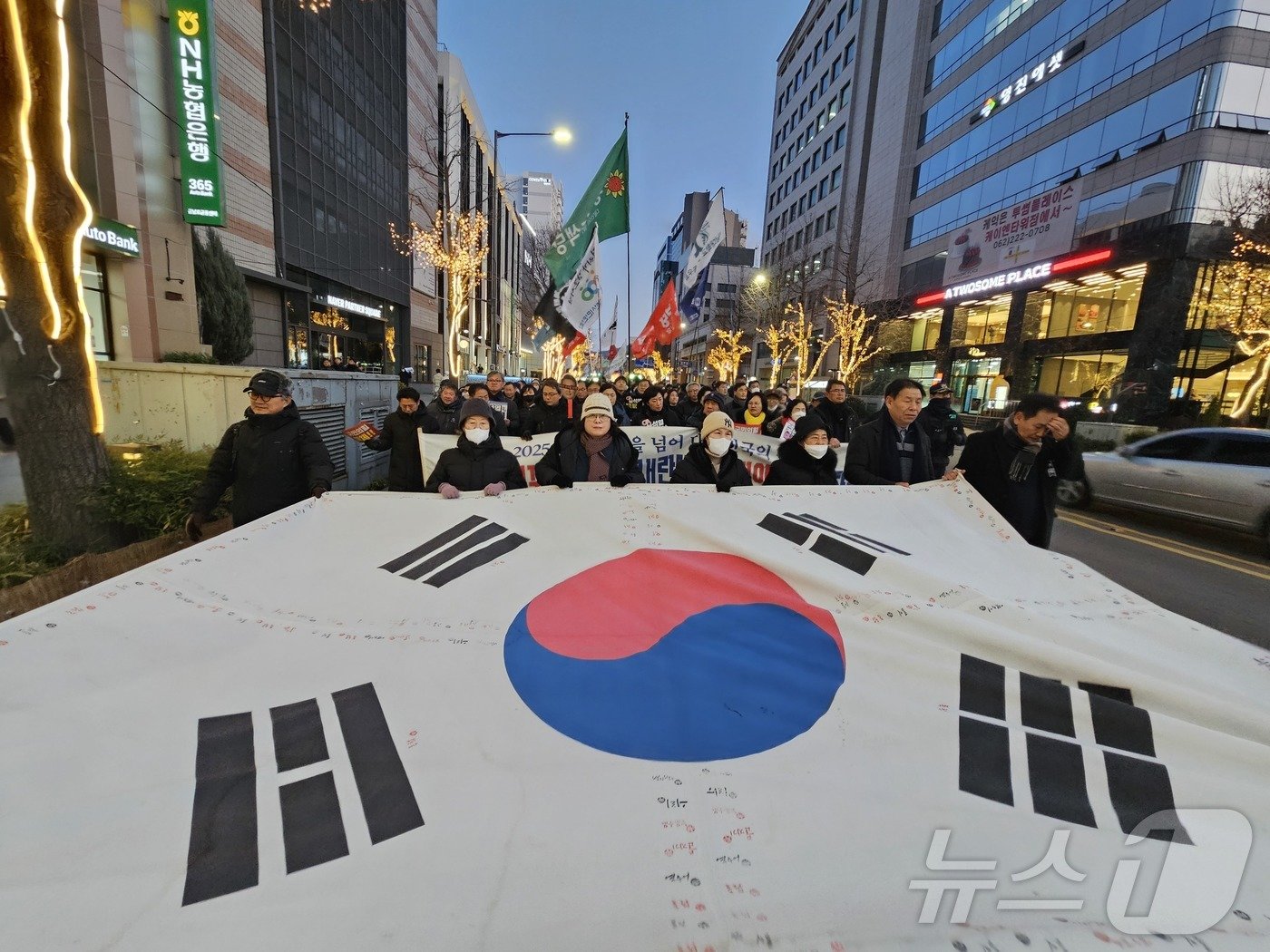 4일 오후 광주 동구 금남로에서 열린 9차 광주시민총궐기대회에서 윤석열 대통령 체포·구속을 촉구하는 시민들이 대형 태극기를 앞세워 행진하고 있다. 2025.1.4/뉴스1 ⓒ News1 서충섭 기자