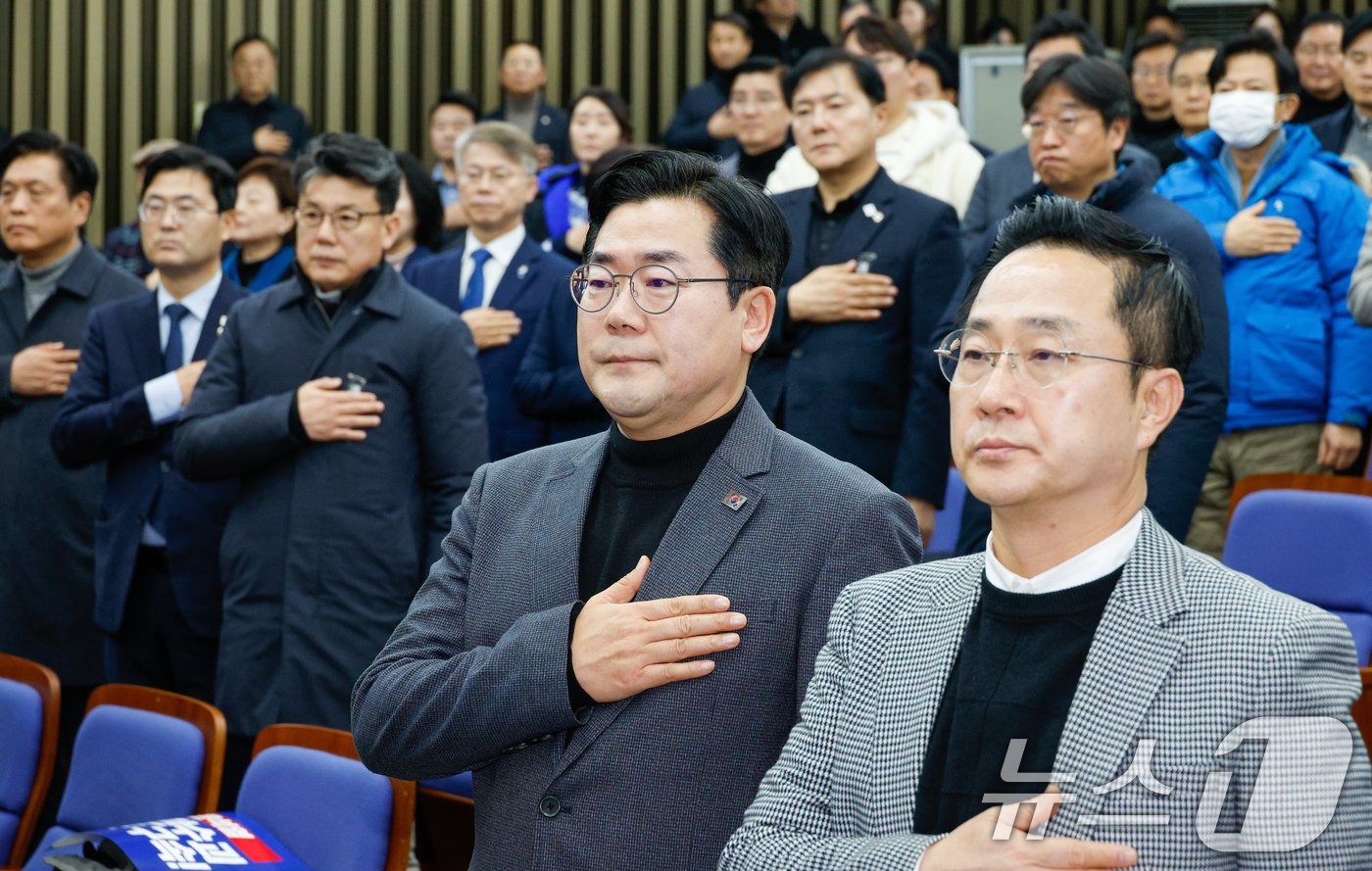 박찬대 더불어민주당 원내대표&#40;앞줄 왼쪽&#41;, 박성준 원내수석부대표가 5일 오후 서울 여의도 국회에서 열린 비상의원총회에 참석해 국민의례를 하고 있다. 2025.1.5/뉴스1 ⓒ News1 안은나 기자