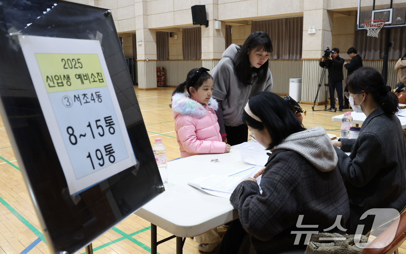 (서울=뉴스1) 송원영 기자 = 6일 오후 서울 서초구 원명초등학교에서 열린 2025학년도 신입생 예비소집에서 예비신입생과 학부모가 취학통지서 접수를 하고 있다. 2025.1.6/ …