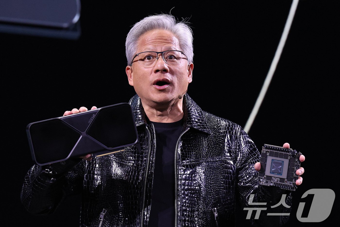 본문 이미지 - 젠슨 황 엔비디아 최고경영자&#40;CEO&#41;가 세계 최대 IT&#40;정보기술&#41;·가전 전시회 &#39;CES 2025&#39; 개막을 하루 앞둔 6일&#40;현지시간&#41; 미국 네바다주 라스베이거스 만달레이베이 컨벤션센터에서 가진 기조연설에서 최신 인공지능&#40;AI&#41; 가속기 &#39;블랙웰&#40;Blackwell&#41;&#39;을 탑재한 지포스 RTX 50 시리즈 그래픽 카드를 공개하고 있다. 2025.1.6/뉴스1 ⓒ News1 신웅수 기자