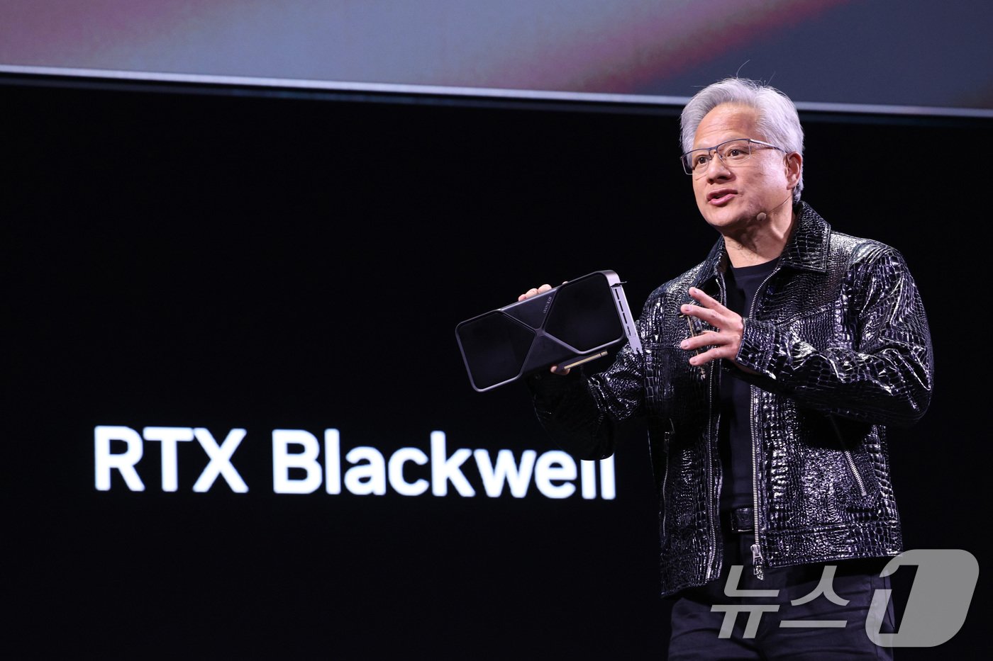 본문 이미지 - 젠슨 황 엔비디아 최고경영자(CEO)가 세계 최대 IT(정보기술)·가전 전시회 'CES 2025' 개막을 하루 앞둔 6일(현지시간) 미국 네바다주 라스베이거스 만달레이베이 컨벤션센터에서 가진 기조연설에서 최신 인공지능(AI) 가속기 '블랙웰(Blackwell)'을 탑재한 지포스 RTX 50 시리즈 그래픽 카드를 공개하고 있다. 2025.1.6/뉴스1 ⓒ News1 신웅수 기자