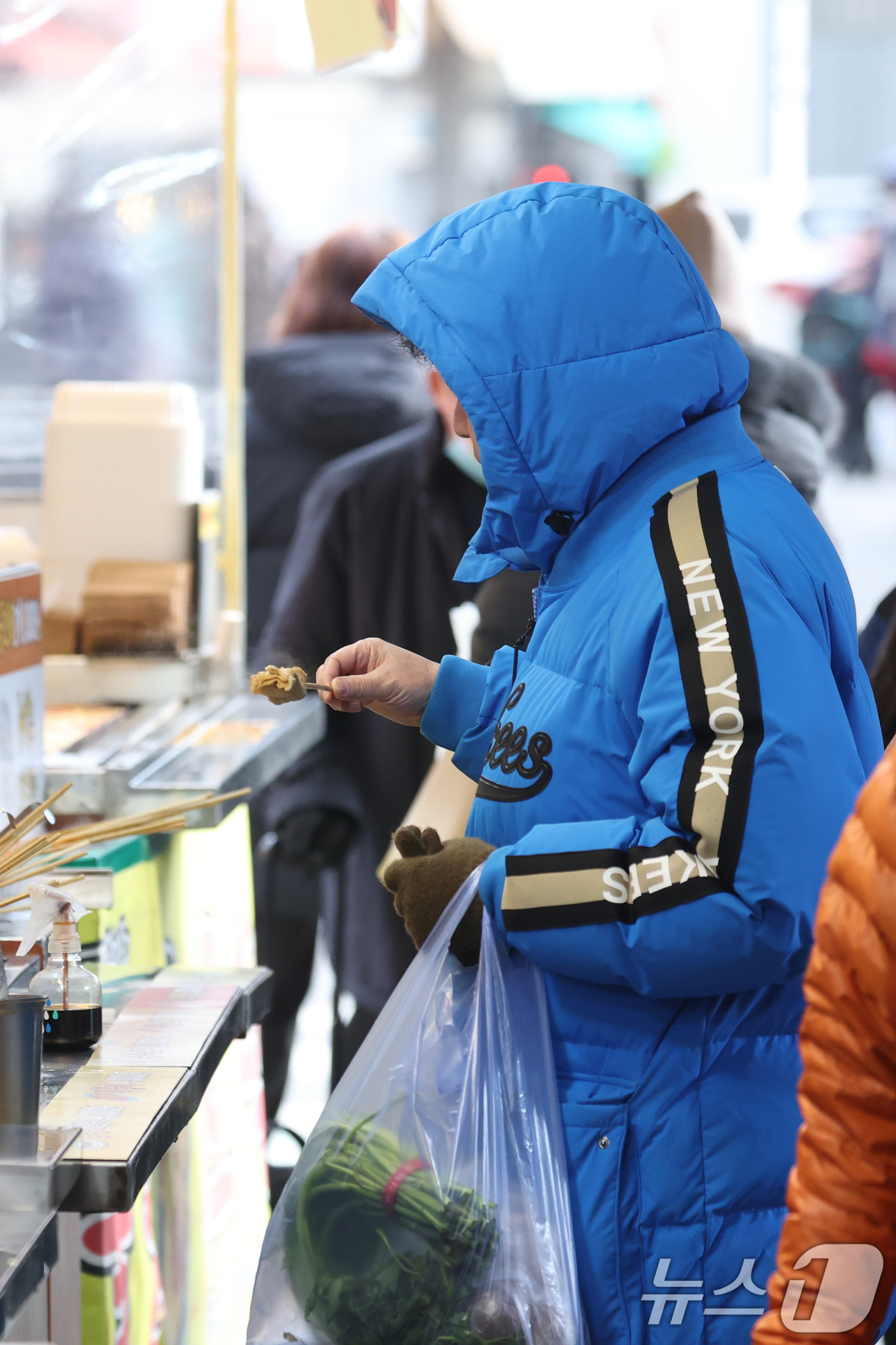 (수원=뉴스1) 김영운 기자 = 본격적인 한파가 시작된 7일 오후 경기 수원시 팔달구 수원화성 팔달문 인근에서 한 시민이 어묵을 먹고 있다. 2025.1.7/뉴스1