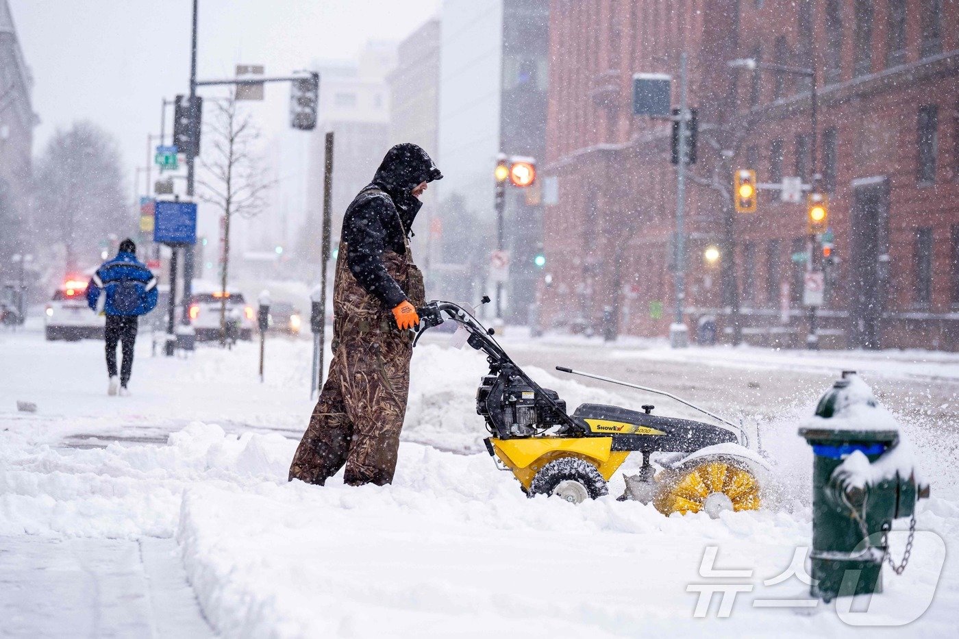 본문 이미지 - 6일 워싱턴 DC에서 한 남성이 노스 캐피톨 스트리트를 따라 눈을 치우고 있다. ⓒ AFP=뉴스1 ⓒ News1 류정민 특파원