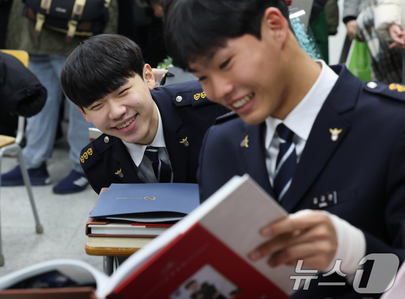 (수원=뉴스1) 김영운 기자 = 8일 오전 경기 수원시 팔달구 삼일공업고등학교에서 열린 졸업식에서 경찰사무행정학과 학생들이 졸업앨범을 보고 있다. 2025.1.8/뉴스1