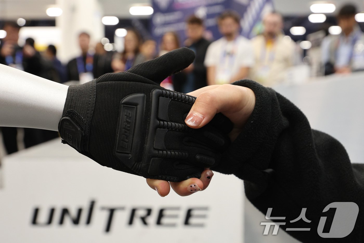 본문 이미지 - 세계 최대 정보기술&#40;IT&#41;·가전 전시회 &#39;CES 2025&#39; 개막일인 7일&#40;현지시간&#41; 미국 네바다주 라스베이거스 컨벤션센터&#40;LVCC&#41;에 마련된 중국 유니트리 부스에서 휴머노이드 로봇 G1이 관람객과 악수하고 있다. 2025.1.8/뉴스1 ⓒ News1 신웅수 기자