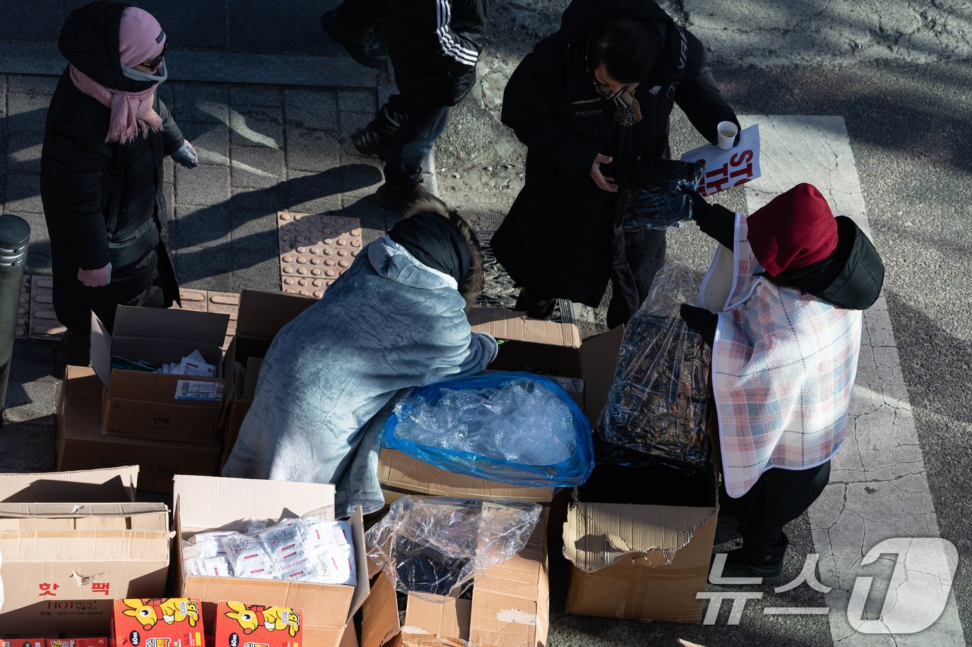 본문 이미지 - 아침 전국 최저기온이 -24.5도, 수도권 -16.1도까지 떨어지며 올겨울 가장 추운 날씨를 보인 9일 오전 보수단체 회원들이 서울 용산구 한남동 대통령 관저 인근에서 윤석열 대통령 탄핵 반대 집회를 하는 가운데 방한용품이 배부되고 있다. 2025.1.9/뉴스1 ⓒ News1 이승배 기자