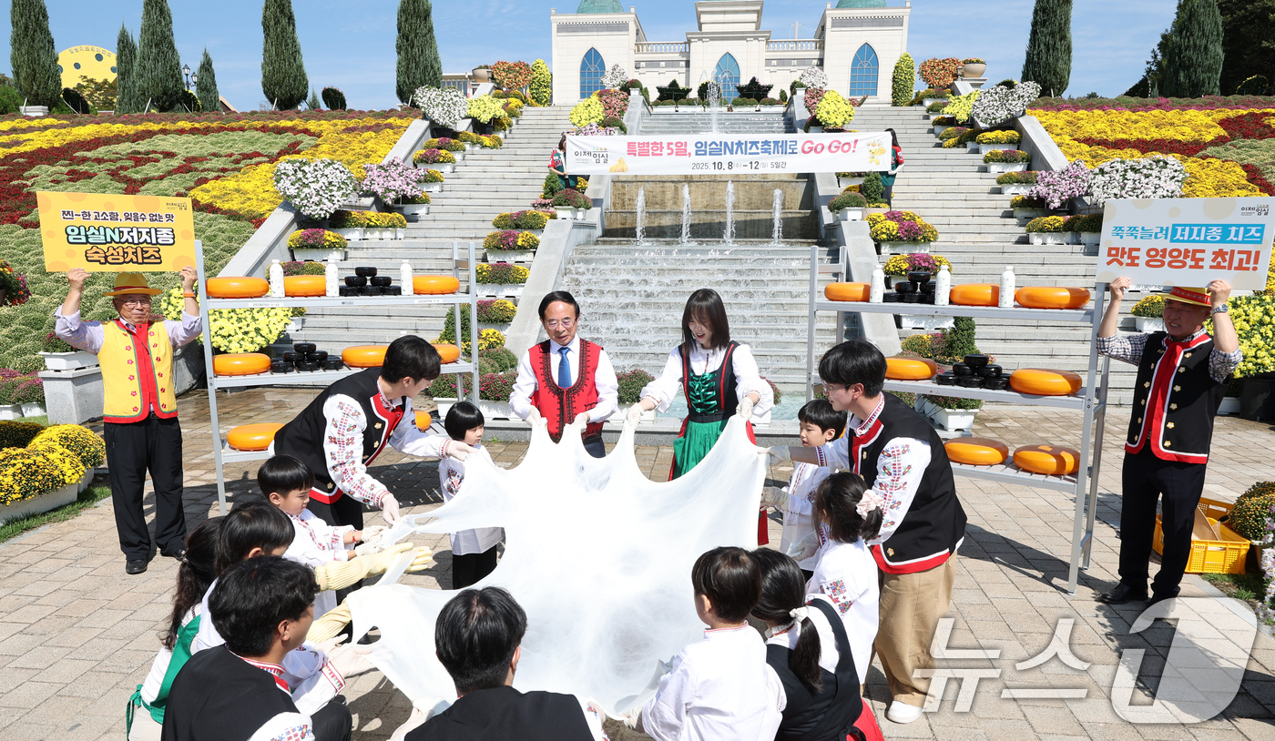 (임실=뉴스1) 유경석 기자 = 심민 임실군수(가운데 왼쪽)가 1일 전북 임실군 치즈테마파크에서 2025 임실N치즈축제 사전 행사에 참여한 어린이들과 저지종 치즈 늘리기 체험을 하 …