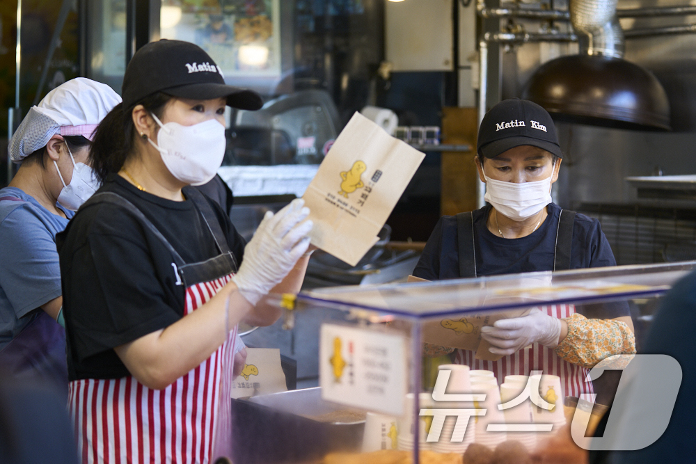 (서울=뉴스1) = 마뗑킴은 광장마켓점 오픈을 기념하여 광장시장 대표 맛집 상인들과 손을 잡고 이색 콜라보레이션을 진행한다고 1일 밝혔다.서울 종로구 광장시장에서 상인들이 볼캡과 …