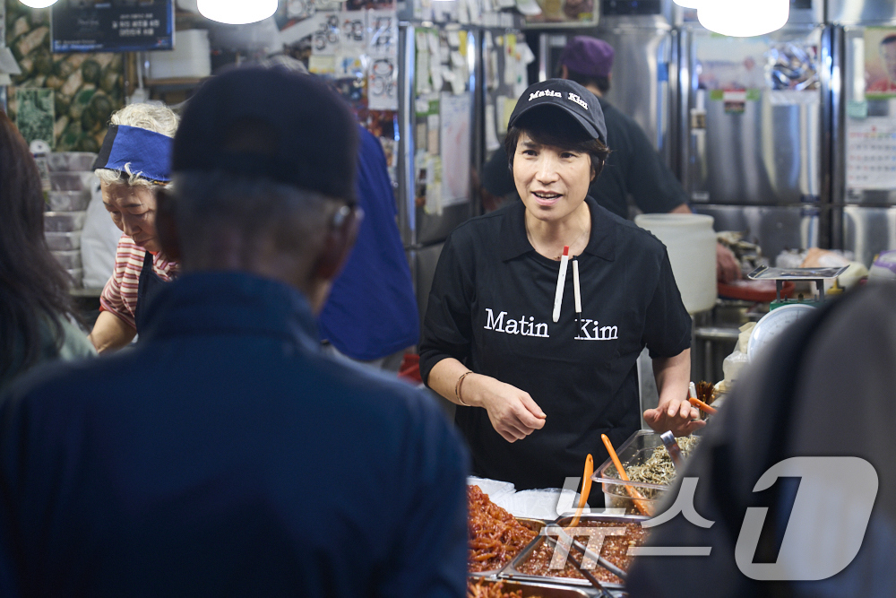 (서울=뉴스1) = 마뗑킴은 광장마켓점 오픈을 기념하여 광장시장 대표 맛집 상인들과 손을 잡고 이색 콜라보레이션을 진행한다고 1일 밝혔다.서울 종로구 광장시장에서 상인들이 볼캡과 …