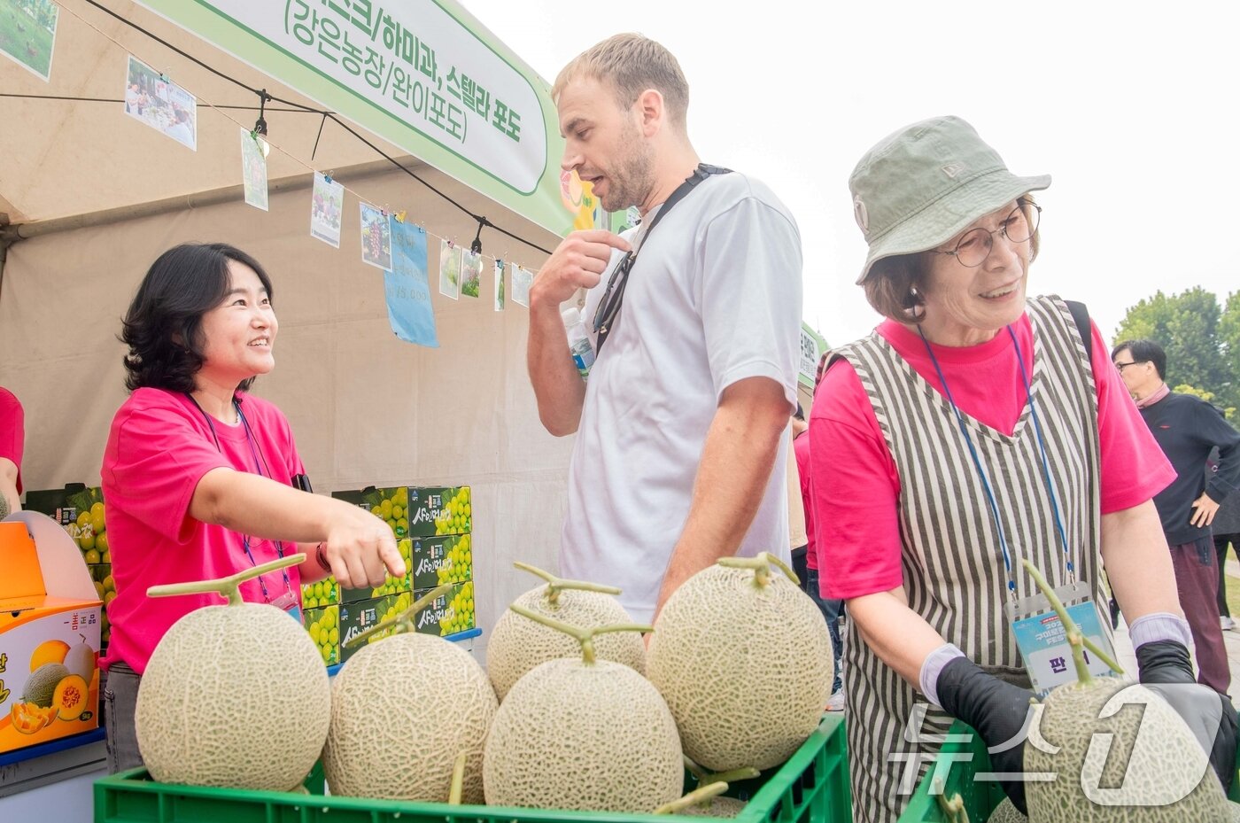 본문 이미지 - 지난 1일 서울광장에서 열린 &#39;구미 로컬푸드 페스타&#39;를 찾은 외국인들이 구미에서 생산된 멜론을 살펴보고 있다. &#40;구미시 제공. 재판매 및 DB금지&#41; 2025.10.1/뉴스1 ⓒ News1 정우용 기자