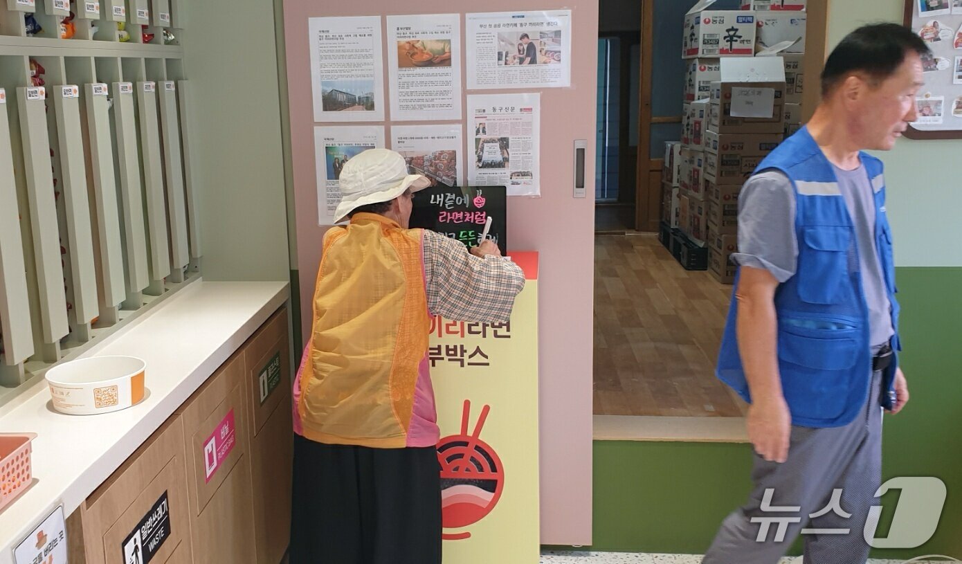 본문 이미지 - 한 손님이 라면을 먹기 전 서명을 하고 있다. 2025.10.1/뉴스1 ⓒ News1 김태형 기자