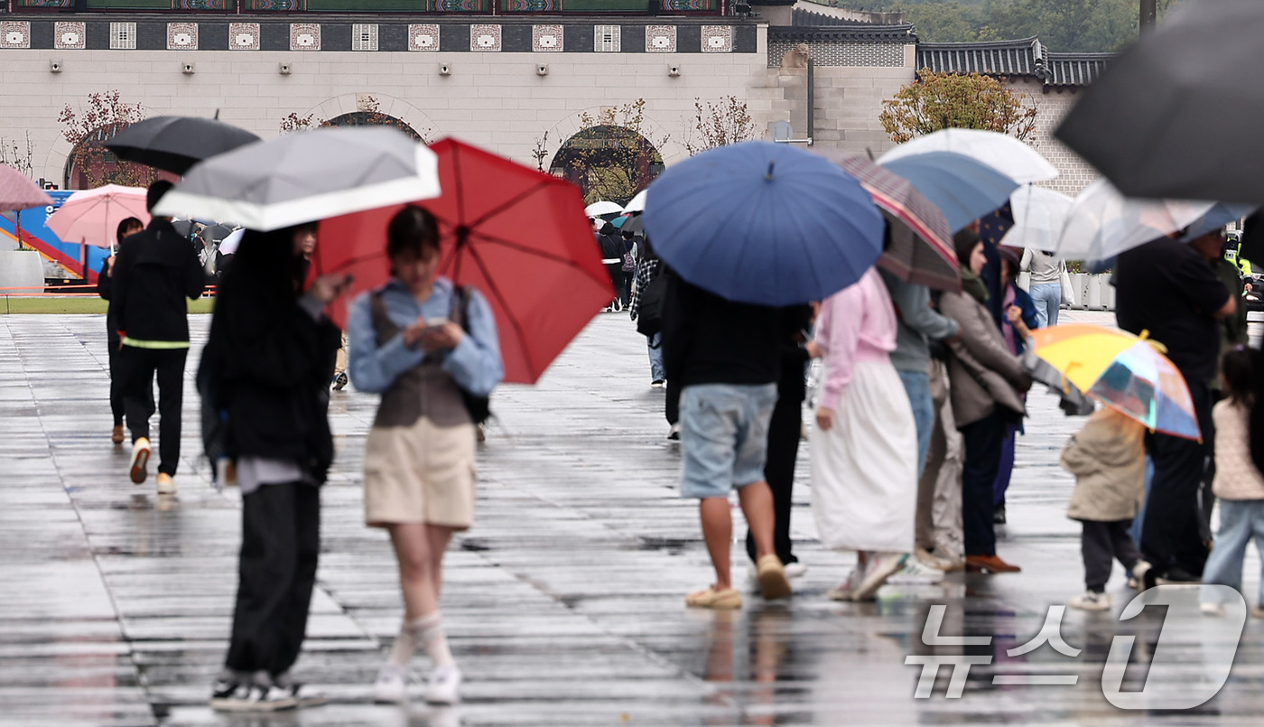 (서울=뉴스1) 김성진 기자 = 추석 연휴가 끝난 10일 서울 종로구 광화문광장에서 시민들이 우산을 쓴 채 발걸음을 옮기고 있다. 2025.10.10/뉴스1