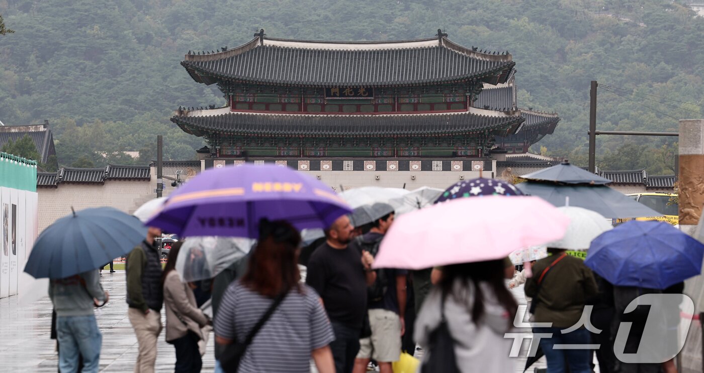 본문 이미지 - 추석 연휴가 끝난 10일 서울 종로구 광화문광장에서 시민들이 우산을 쓴 채 발걸음을 옮기고 있다. 2025.10.10/뉴스1 ⓒ News1 김성진 기자