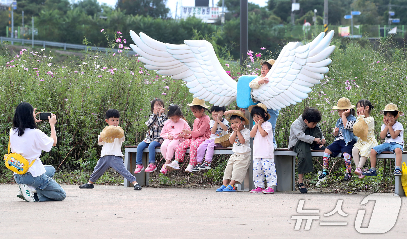 (경산=뉴스1) 공정식 기자 = 10일 오후 경북 경산시 하양읍 대부잠수교 옆 하양경관농업단지로 나들이 나온 어린이들이 천사 날개 조형물 앞에서 기념 촬영을 하고 있다. 2025. …