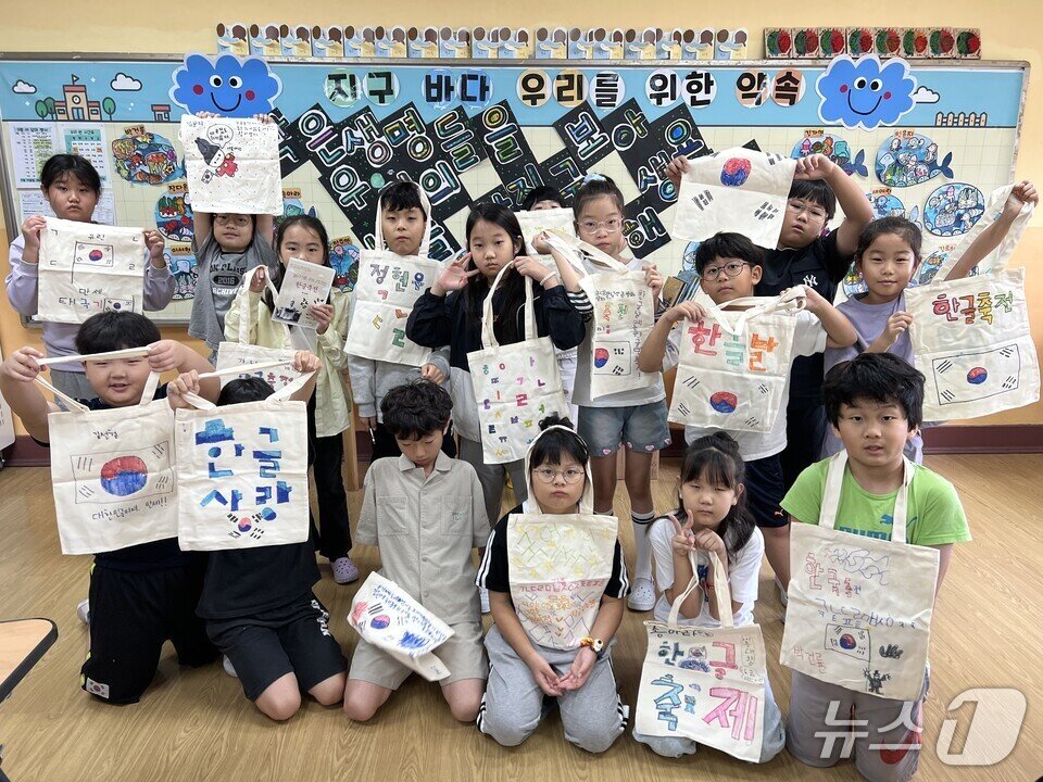본문 이미지 - 학생들이 한글을 소재로 만든 주머니 등을 들어보이며 기념사진을 찍고 있다.&#40;전남도교육청 제공, 재판매 및 DB 금지&#41;/뉴스1 
