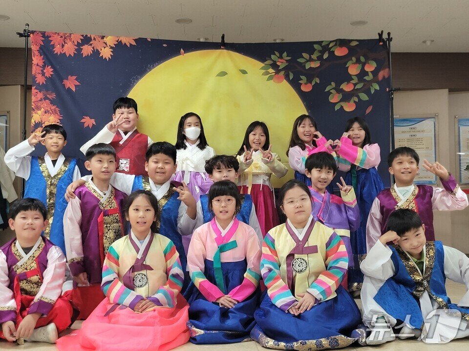 본문 이미지 - 한복을 입은 학생들이 보름달 그림을 배경으로 기념사진을 찍고 있다.&#40;전남도교육청 제공, 재판매 및 DB 금지&#41;/뉴스1 