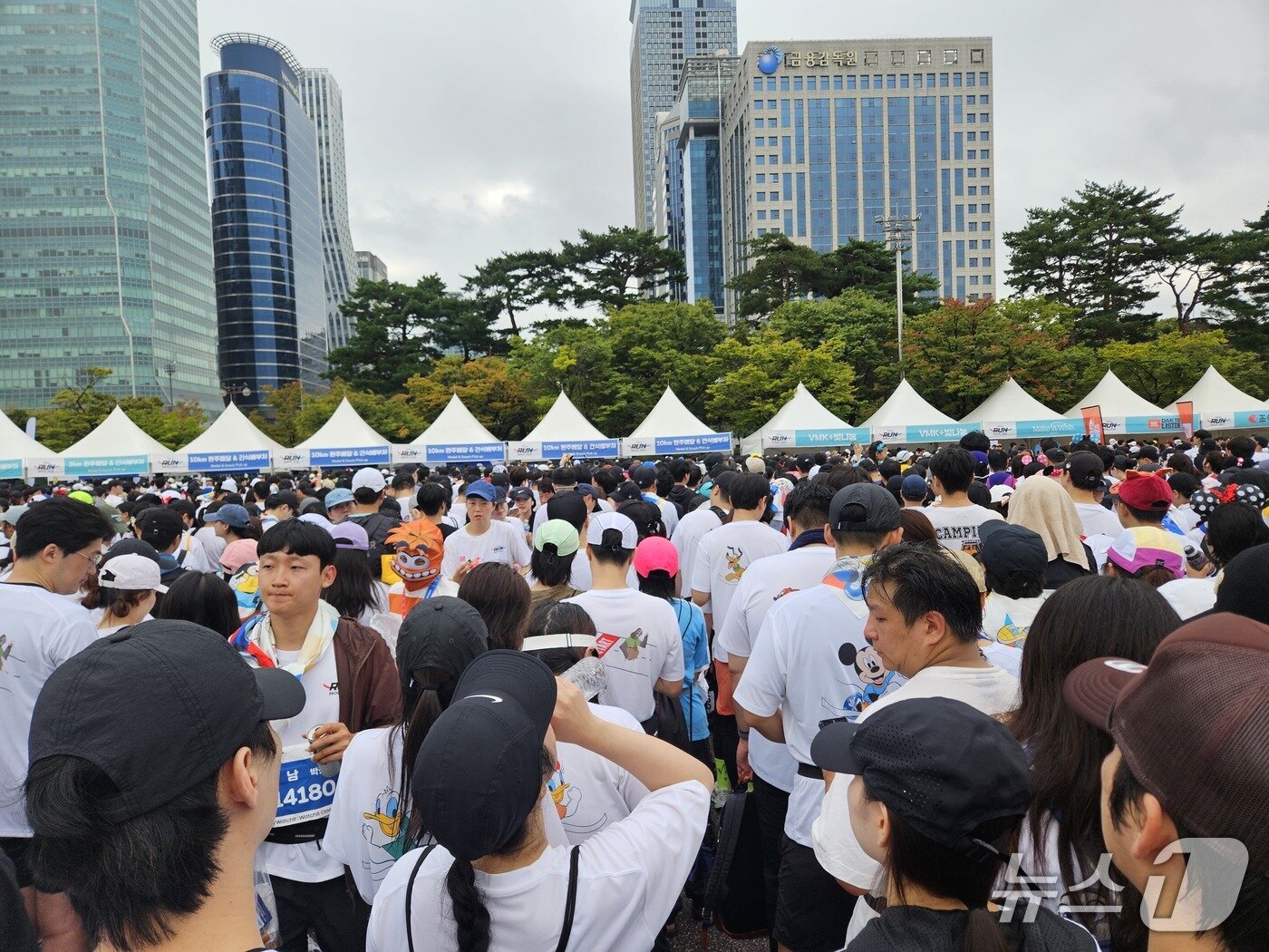 본문 이미지 - 11일 서울 여의도공원 일대에서 &#39;디즈니런 서울 2025&#39;&#40;Disney Run 2025&#41;이 개최됐다. 러닝 후 음료 및 메달 수령을 기다리는 사람들 모습.ⓒ 뉴스1/김진희 기자.