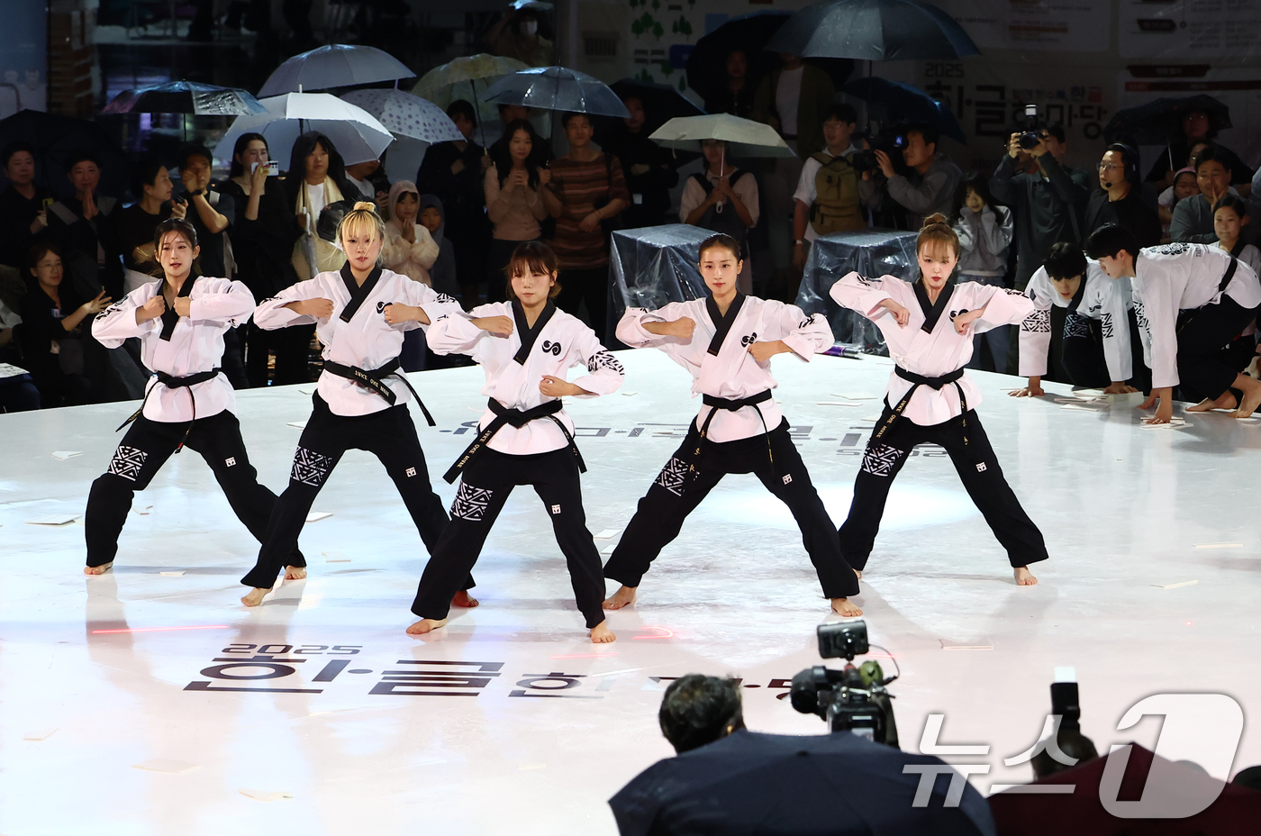 (서울=뉴스1) 김민지 기자 = 11일 서울 종로구 광화문광장에서 열린 2025 한글한마당 행사에서 시민들이 태권한류 팀의 태권도 공연을 보고 있다. 2025.10.11/뉴스1