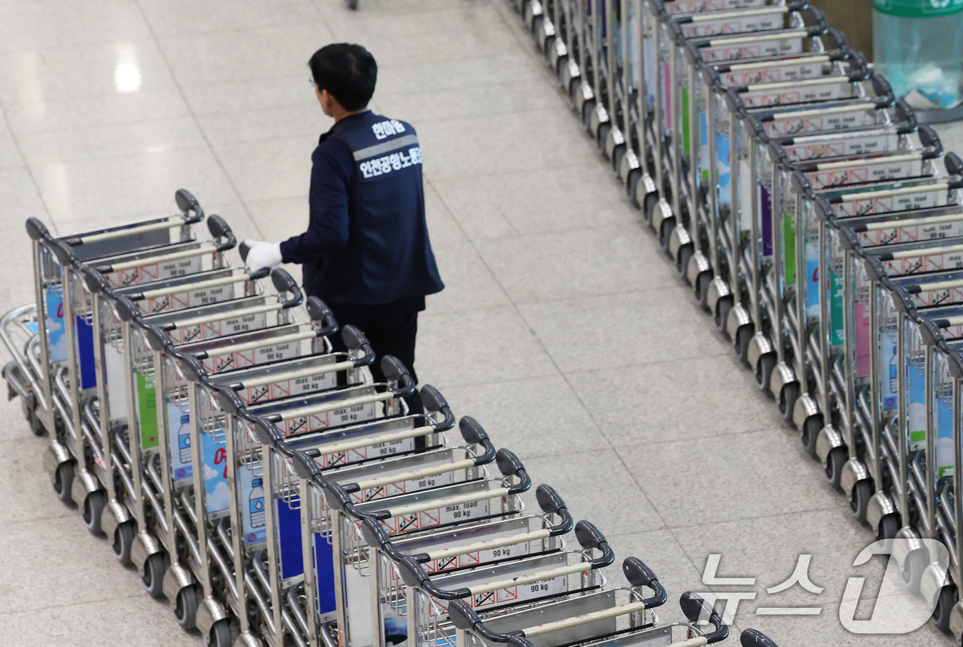 (인천공항=뉴스1) 오대일 기자 = 열흘 간의 파업을 마치고 업무 현장에 복귀한 인천국제공항 노동자가 12일 인천국제공항 1터미널 입국장에서 카트를 정리하고 있다.근로조건 개선을 …