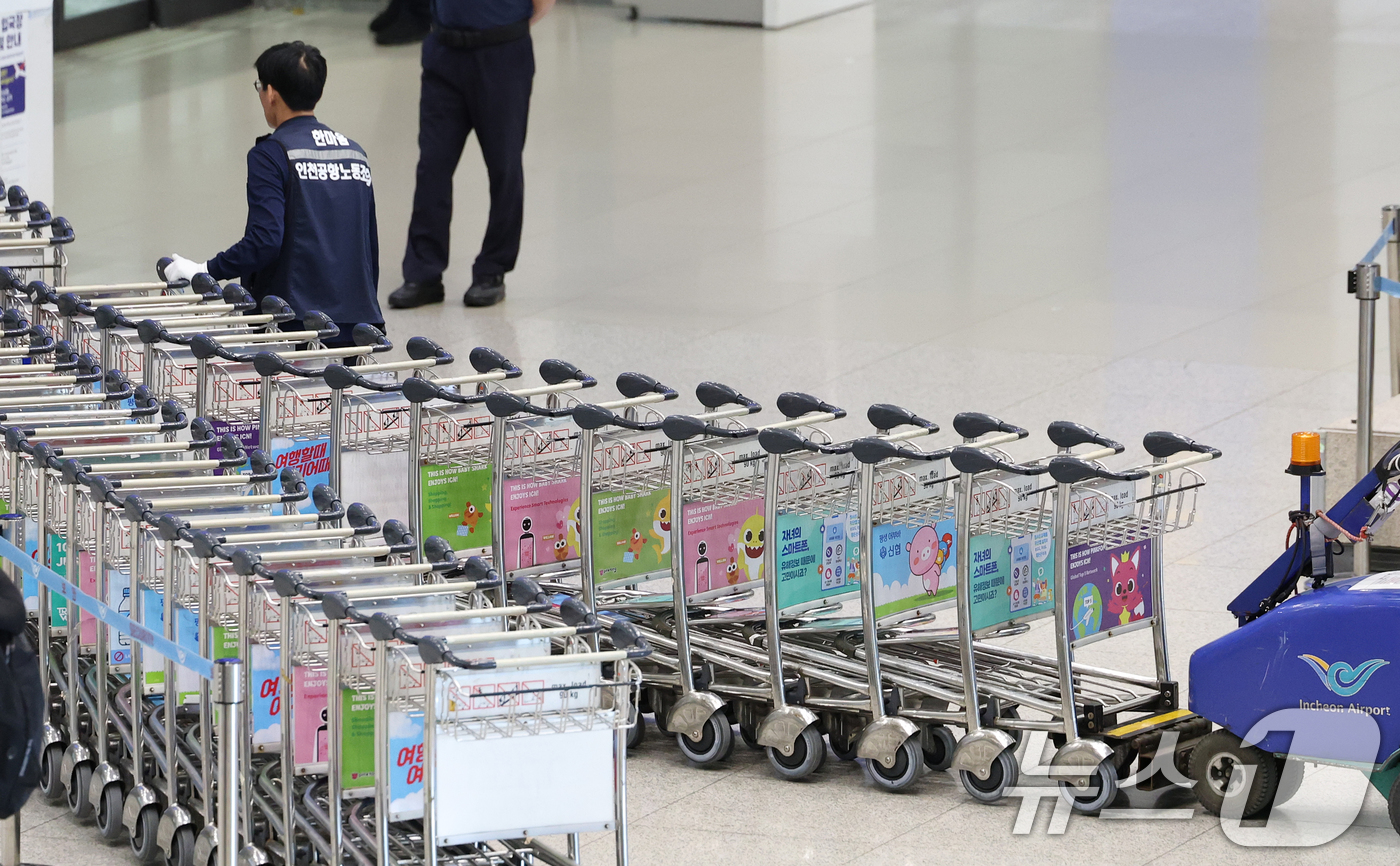 (인천공항=뉴스1) 오대일 기자 = 열흘 간의 파업을 마치고 업무 현장에 복귀한 인천국제공항 노동자가 12일 인천국제공항 1터미널 입국장에서 카트를 정리하고 있다.근로조건 개선을 …