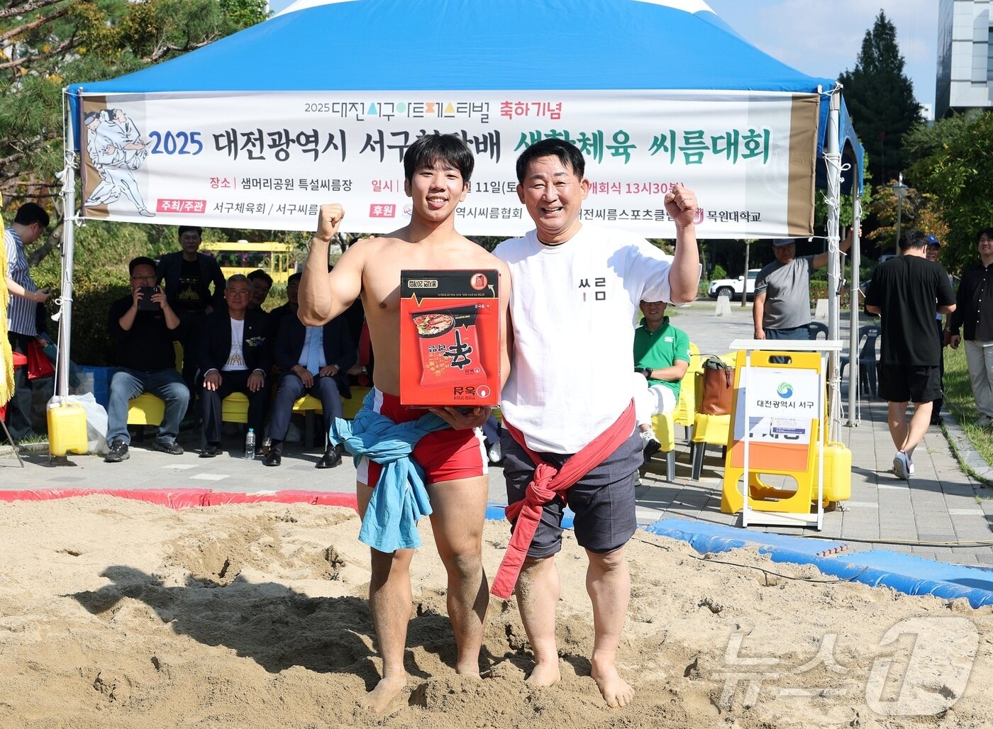 본문 이미지 - 서철모 대전 서구청장이 11일 대전 서구 샘머리공원과 보라매공원 일대에서 2025 아트페스티벌 축제 일환으로 열진 서구청장배 생활체육 씨름대회에서 우승자와 포즈를 취하고 있다. ‘너의 폼을 뽐내봐!’를 주제로 열린 이번 축제는 지역과 전국의 예술가 100여 명이 참여한 아트마켓을 비롯해 공연과 체험 프로그램 등 다채로운 볼거리로 구성됐다.(서구 제공. 재판매 및 DB금지) 2025.10.12/뉴스1 ⓒ News1 김기태 기자