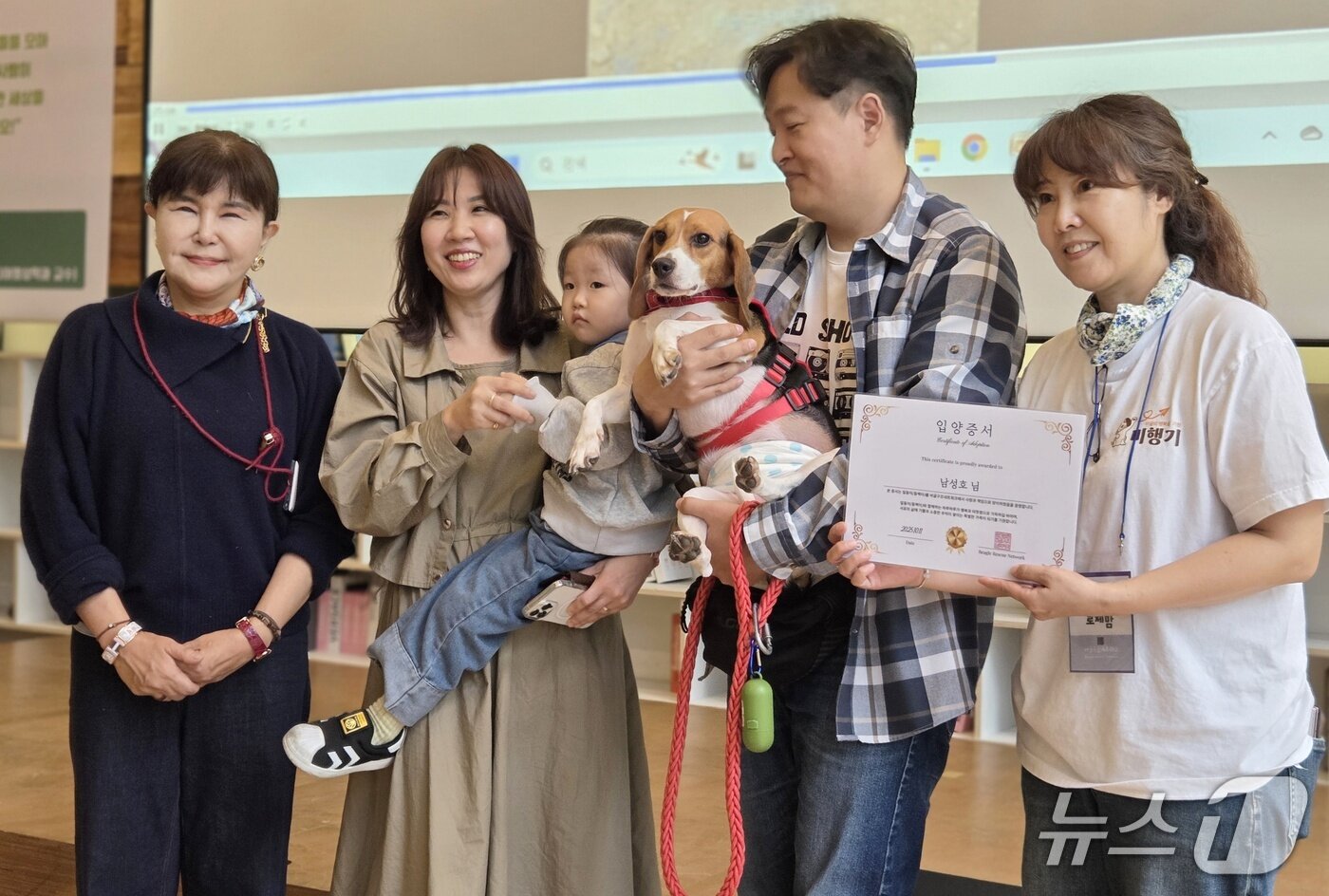 본문 이미지 - 강소영 서울디지털대학교 교수&#40;맨 왼쪽&#41;와 김세현 비글구조네트워크 대표&#40;맨 오른쪽&#41;가 제1회 입양제를 통해 입양 간 비글 &#39;동백이&#39; 가족에게 입양증서를 전달한 후 기념 사진을 찍고 있다. ⓒ 뉴스1 한송아 기자