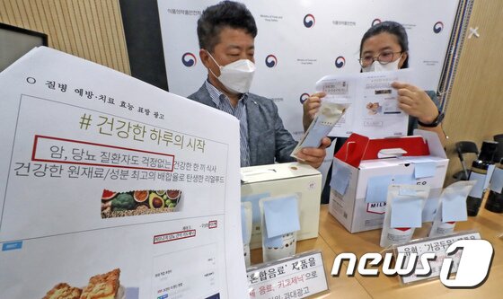 본문 이미지 - 식품의약품안전처 관계자들이 과장 광고를 적발해 위반 사례를 소개하고 있다./뉴스1