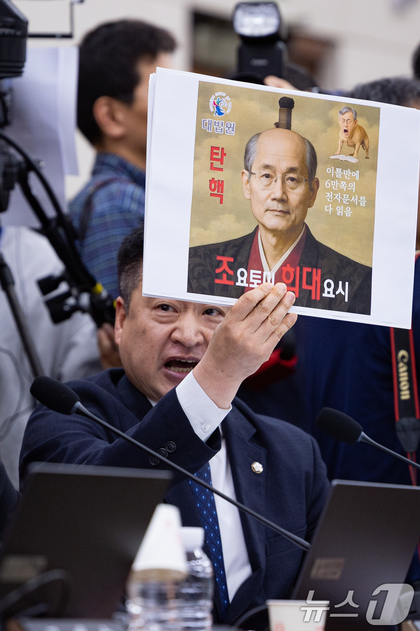 (서울=뉴스1) 유승관 기자 = 최혁진 무소속 의원이 13일 서울 여의도 국회에서 열린 법제사법위원회의 대법원 등에 대한 국정감사에서 조희대 대법원장에게 질의하며 손팻말을 들어보이 …