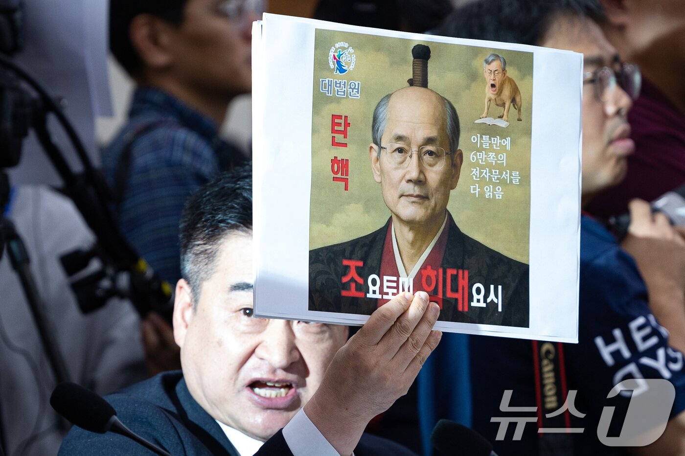본문 이미지 - 최혁진 무소속 의원이 13일 서울 여의도 국회에서 열린 법제사법위원회의 대법원 등에 대한 국정감사에서 조희대 대법원장에게 질의하며 손팻말을 들어보이고 있다. 2025.10.13/뉴스1 ⓒ News1 유승관 기자