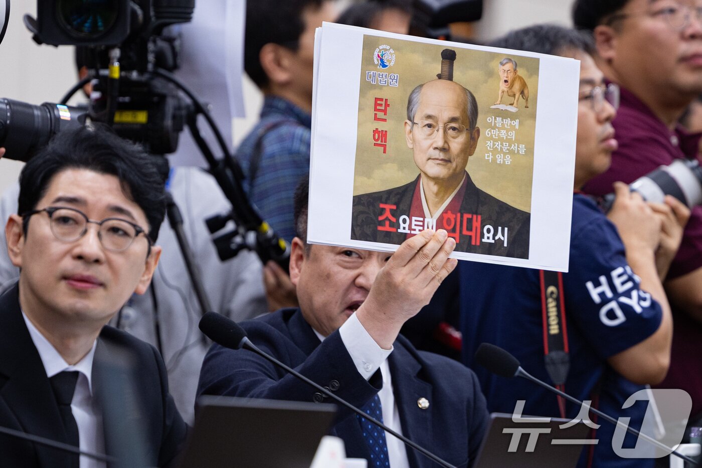 본문 이미지 - 최혁진 무소속 의원이 13일 서울 여의도 국회에서 열린 법제사법위원회의 대법원 등에 대한 국정감사에서 조희대 대법원장에게 질의하며 손팻말을 들어보이고 있다. 2025.10.13/뉴스1 ⓒ News1 유승관 기자