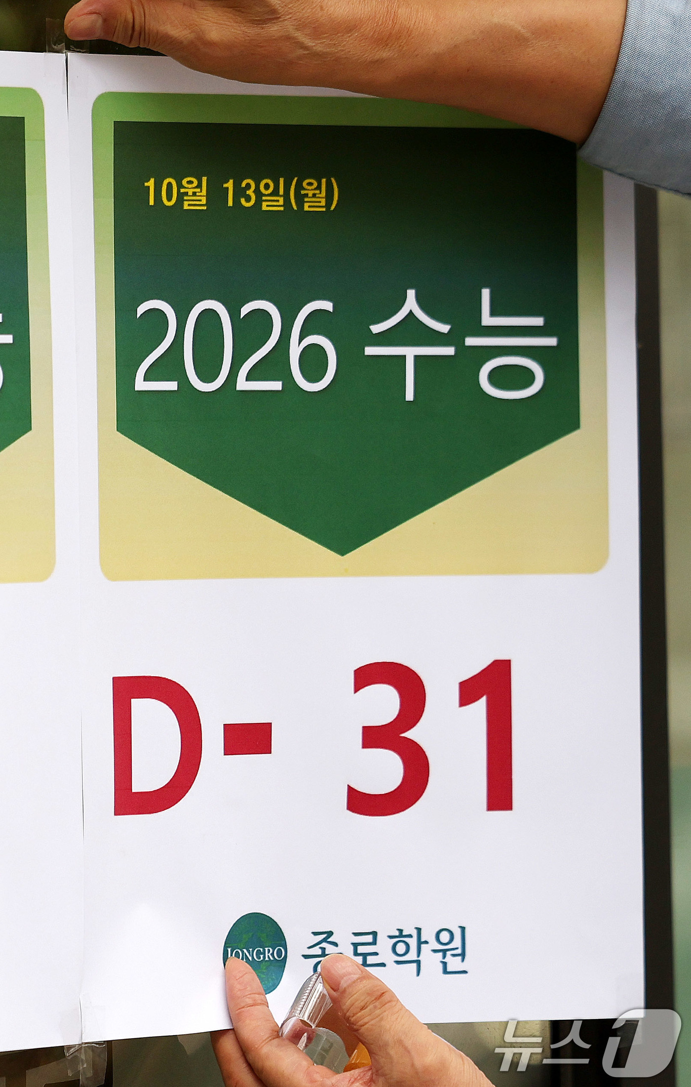 (서울=뉴스1) 박지혜 기자 = 2026학년도 대학수학능력시험을 한달 앞둔 13일 서울 마포구 강북종로학원에서 학원 관계자가 수능 D-31 안내문을 붙이고 있다.올해 대학수학능력시 …