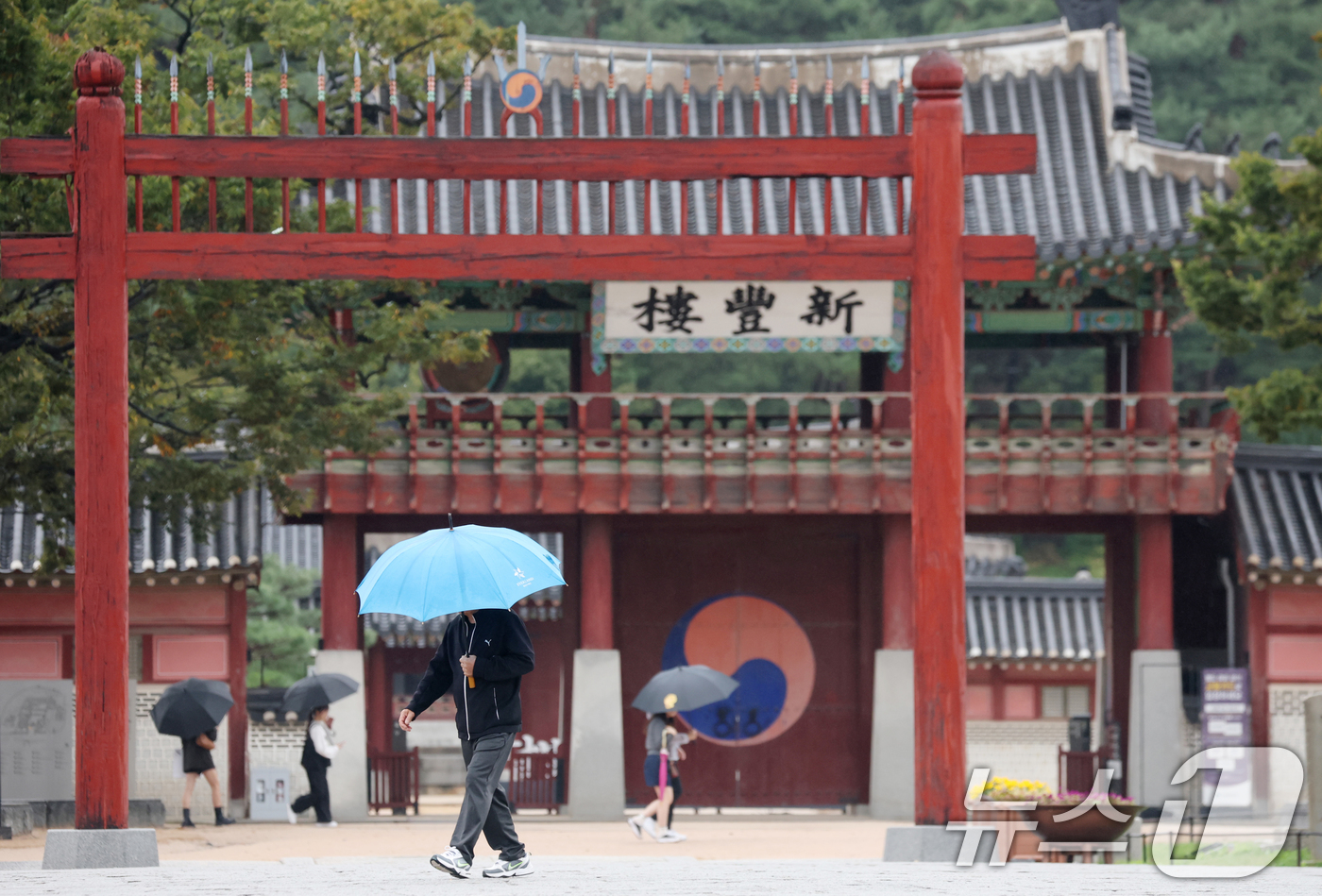 (수원=뉴스1) 김영운 기자 = 수도권에 곳곳에 비가 내리고 있는 13일 경기 수원시 팔달구 수원화성 화성행궁 인근에서 시민들이 우산을 쓰고 걸어가고 있다. 2025.10.13/뉴 …