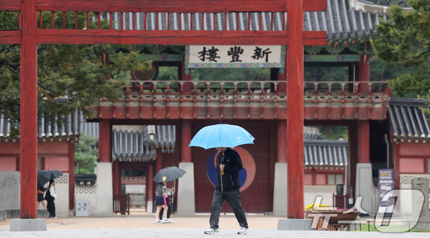 (수원=뉴스1) 김영운 기자 = 수도권에 곳곳에 비가 내리고 있는 13일 경기 수원시 팔달구 수원화성 화성행궁 인근에서 시민들이 우산을 쓰고 걸어가고 있다. 2025.10.13/뉴 …