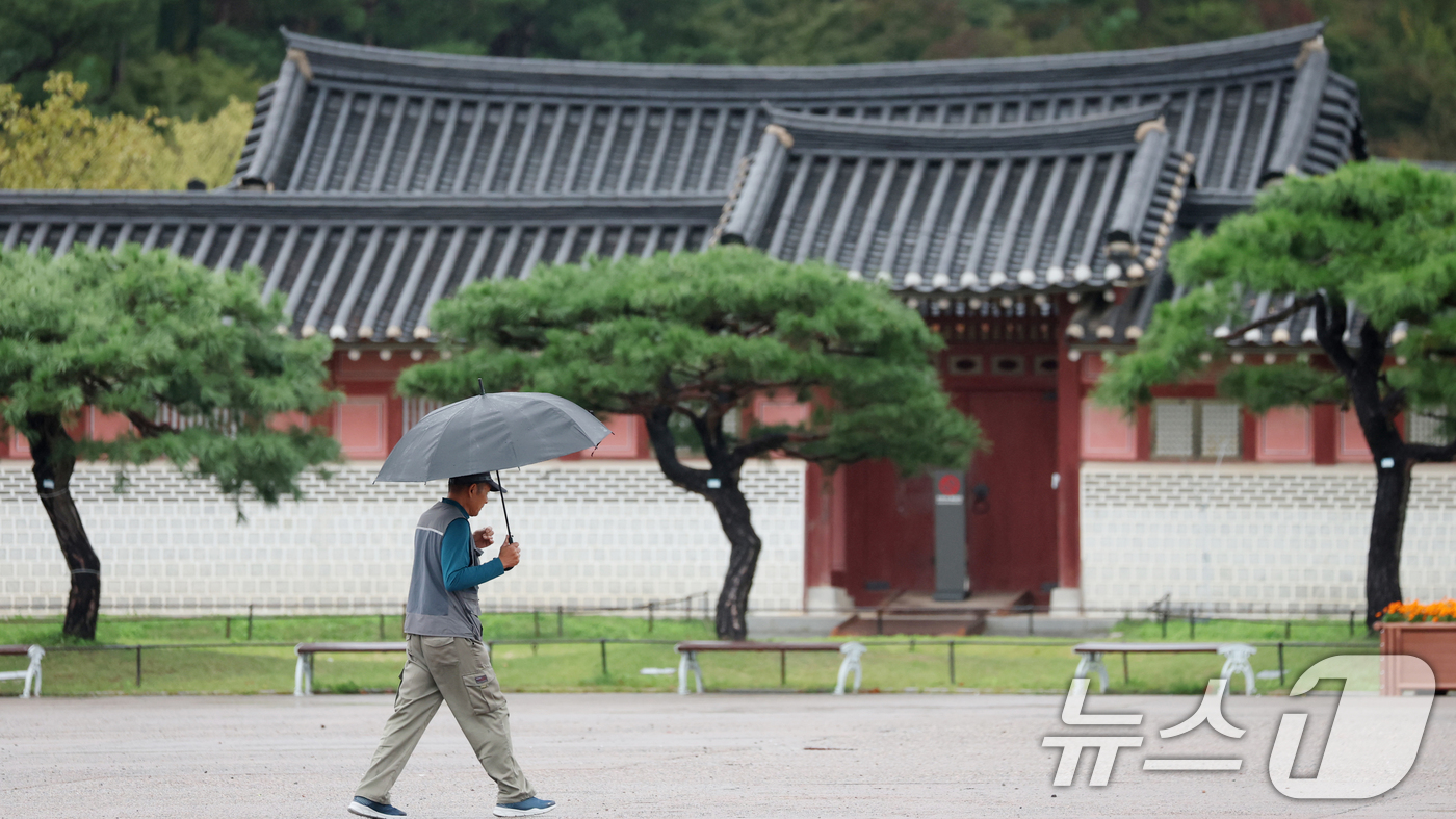 (수원=뉴스1) 김영운 기자 = 수도권에 곳곳에 비가 내리고 있는 13일 경기 수원시 팔달구 수원화성 화성행궁 인근에서 시민들이 우산을 쓰고 걸어가고 있다. 2025.10.13/뉴 …