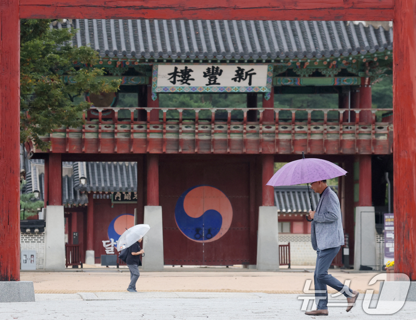 (수원=뉴스1) 김영운 기자 = 수도권에 곳곳에 비가 내리고 있는 13일 경기 수원시 팔달구 수원화성 화성행궁 인근에서 시민들이 우산을 쓰고 걸어가고 있다. 2025.10.13/뉴 …