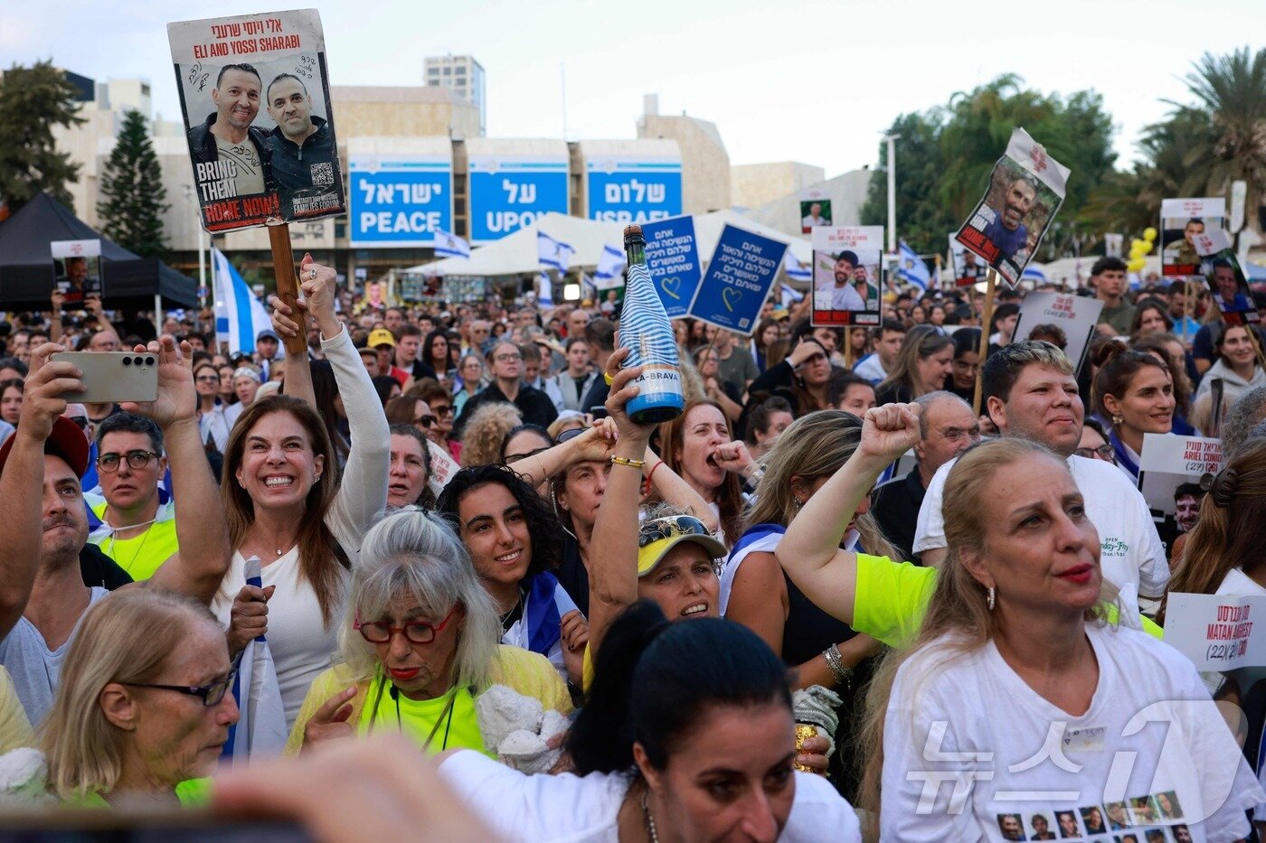 본문 이미지 - 팔레스타인 무장정파 하마스가 13일(현지시간) 이스라엘 인질 7명을 풀어주면서 인질 석방을 시작했다. 이스라엘 국민들이 광장에 모여 인질의 귀환 상황을 지켜보고 있다. 2025.10.13. ⓒ AFP=뉴스1