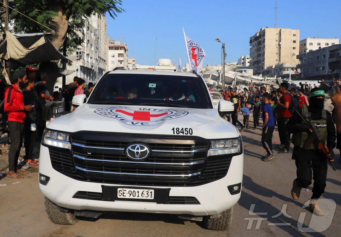 본문 이미지 - 적십자 차량이 13일&#40;현지시간&#41; 가자지구에 억류되어 있던 인질을 인도받은 뒤 이송하고 있다. 2025.10.13./뉴스1 ⓒ 로이터=뉴스1 ⓒ News1 이창규 기자