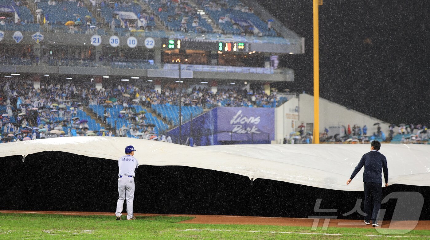 본문 이미지 - 13일 오후 대구 삼성라이온즈파크에서 열린 프로야구 2025 신한 SOL뱅크 KBO 준플레이오프 3차전 SSG 랜더스와 삼성 라이온즈의 경기, 1회말 삼성 공격 중 갑작스러운 폭우로 경기가 중단되며 대형 방수포가 설치되고 있다. 2025.10.13/뉴스1 ⓒ News1 김진환 기자