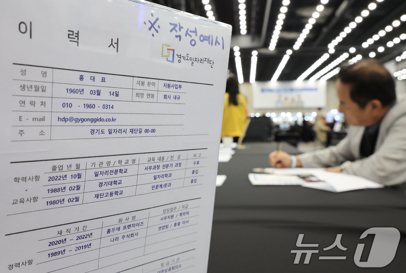 본문 이미지 - 경기도 일산 킨텍스 제2전시장에서 지난해 10월 14일 열린 ‘경기도 5070 일자리 박람회’를 방문한 구직자가 이력서를 작성하고 있다. ⓒ 뉴스1 이호윤 기자