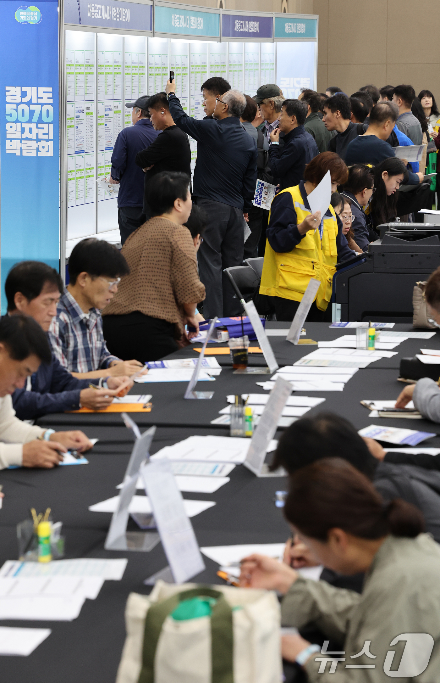 (고양=뉴스1) 이호윤 기자 = 14일 경기도 일산 킨텍스 제2전시장에서 열린 ‘경기도 5070 일자리 박람회’를 방문한 구직자들이 이력서 작성과 구인공고를 살펴보고 있다. 이번 …