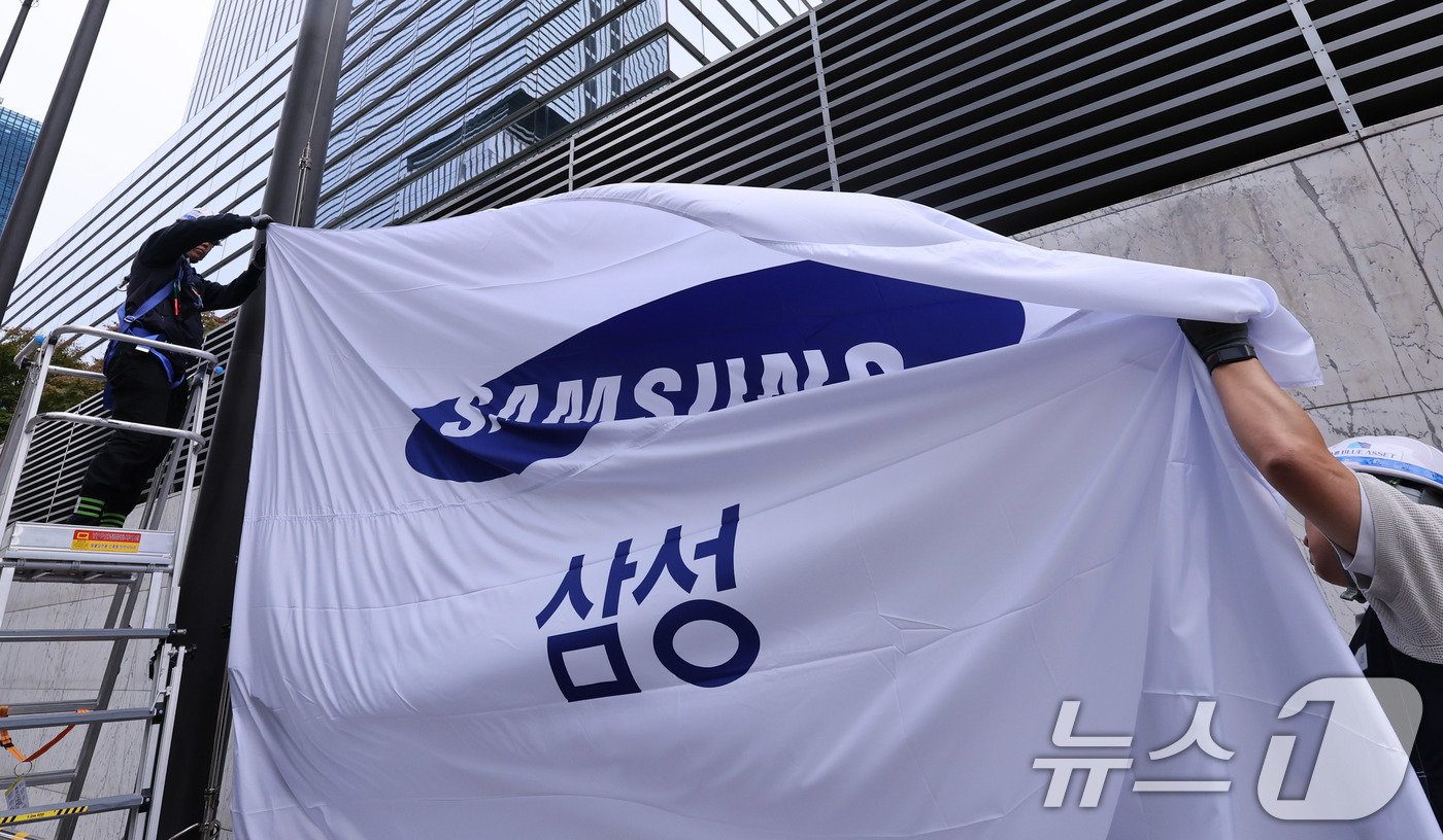 (서울=뉴스1) 박지혜 기자 = 14일 서울 서초구 삼성전자 서초사옥에서 관계자들이 사기를 새 것으로 교체해 게양하고 있다.이날 삼성전자는 올 3분기 12조 원대의 영업이익을 기록 …