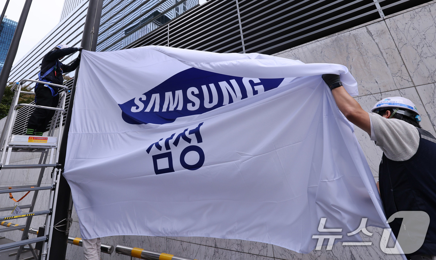 (서울=뉴스1) 박지혜 기자 = 14일 서울 서초구 삼성전자 서초사옥에서 관계자들이 사기를 새 것으로 교체해 게양하고 있다.이날 삼성전자는 올 3분기 12조 원대의 영업이익을 기록 …