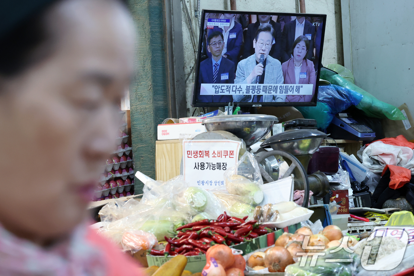 (서울=뉴스1) 박정호 기자 = 14일 오후 서울시 서대문구 인왕시장 한 채소 매장 TV에 지역 상권 활성화와 소비쿠폰을 주제로 한 '디지털 토크 라이브' 생중계가 틀어져 있다. …