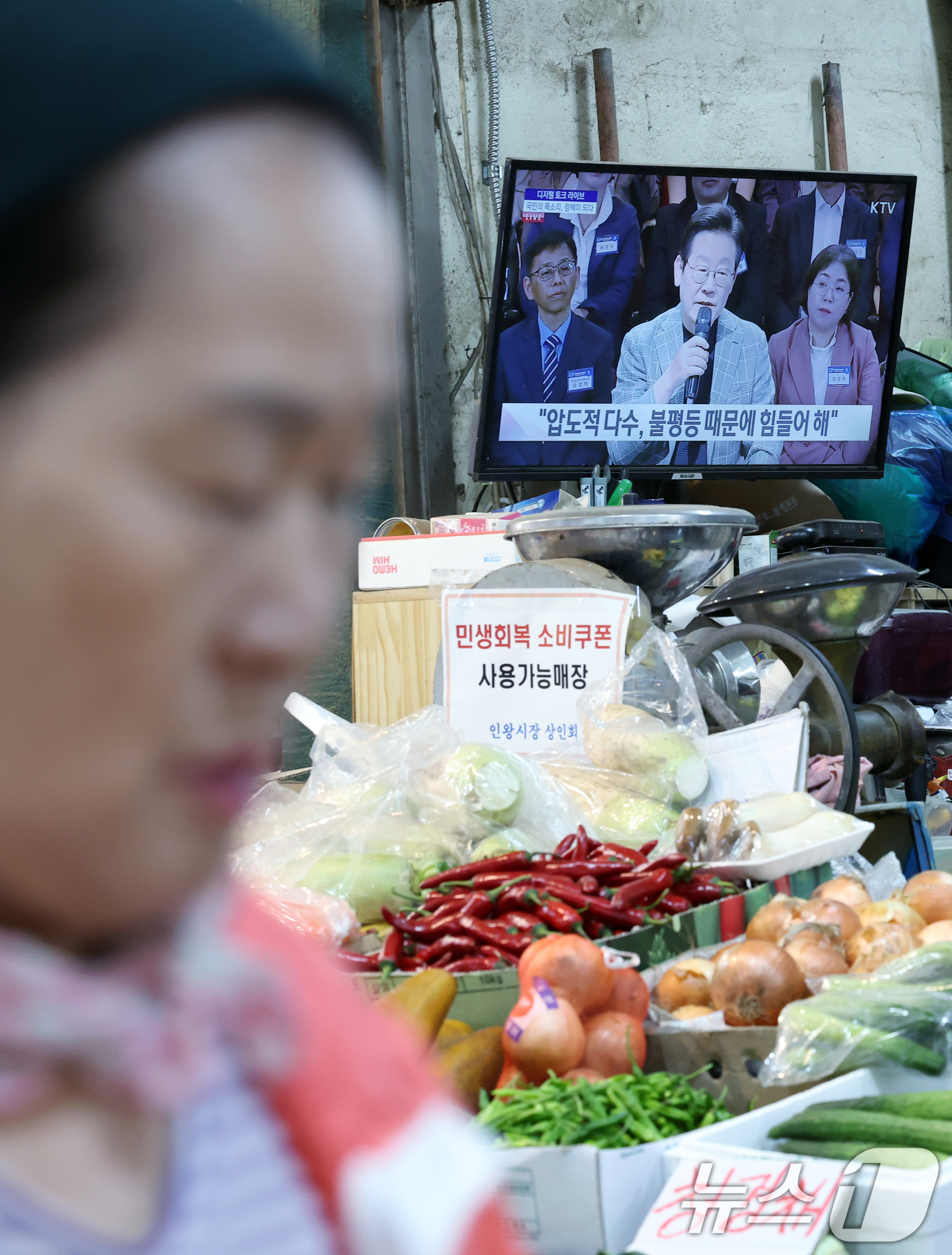 (서울=뉴스1) 박정호 기자 = 14일 오후 서울시 서대문구 인왕시장 한 채소 매장 TV에 지역 상권 활성화와 소비쿠폰을 주제로 한 '디지털 토크 라이브' 생중계가 틀어져 있다. …