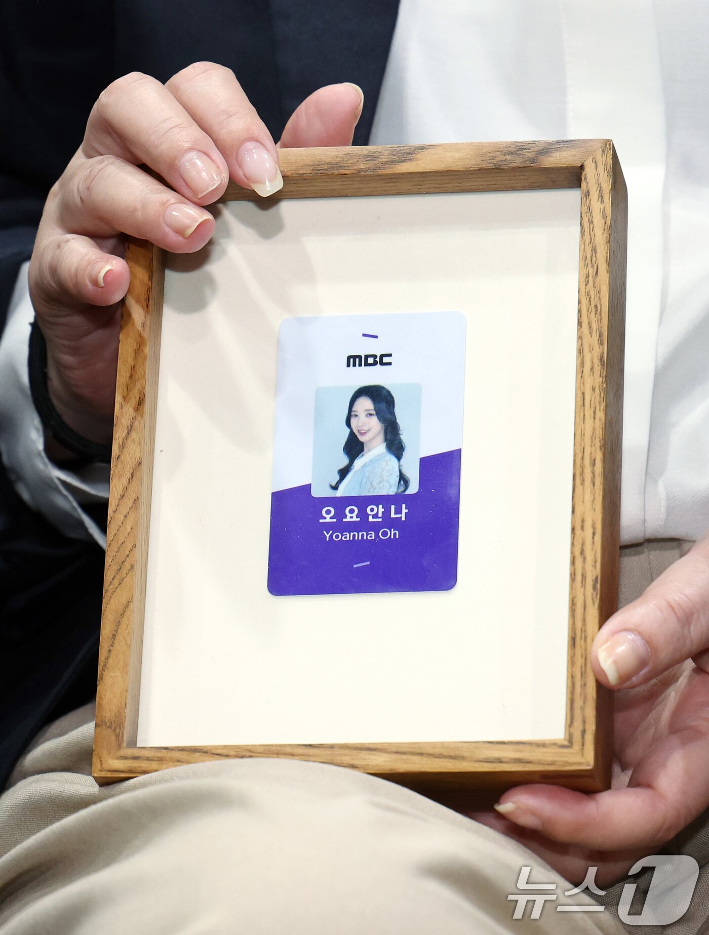 본문 이미지 - 직장 내 괴롭힘을 호소하며 스스로 목숨을 끊은 MBC 기상캐스터 오요안나 씨의 어머니 장연미 씨가 15일 오전 서울시 마포구 상암동 MBC 상암사옥 골든마우스홀에서 열린 MBC-고 오요안나 유족 기자회견에서 고인의 명예 사원증을 들어 보이고 있다. 2025.10.15/뉴스1 ⓒ News1 박정호 기자