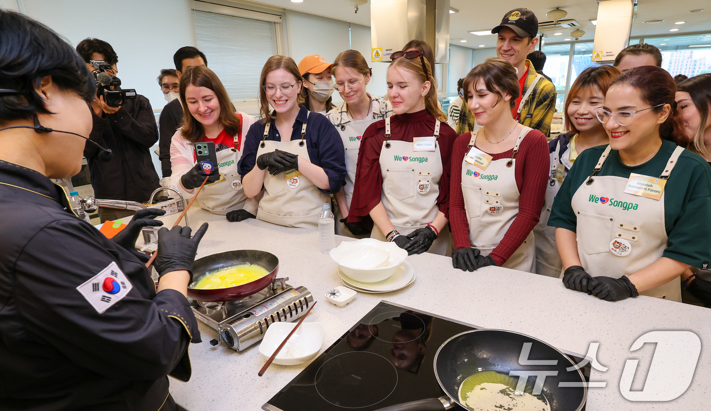 (서울=뉴스1) 안은나 기자 = 15일 서울 송파구 가락몰 쿠킹스튜디오에서 열린 코리안푸드 쿠킹클래스에서 외국인들이 김밥 만드는 과정을 지켜보고 있다. 송파구는 한국에 체류 중인 …