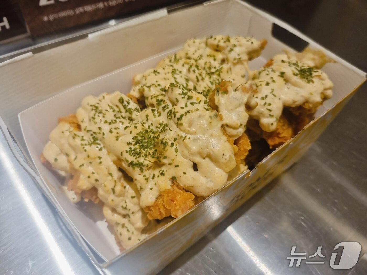 본문 이미지 - 맘스터치가 15일 서울 맘스터치LAB DDP점에서 에드워드 리 셰프와 협업한 2차 컬렉션 신제품 '크림디종 빅싸이순살'을 선보이고 있다. 2025.10.15 / 뉴스1  박혜연 기자 ⓒ News1