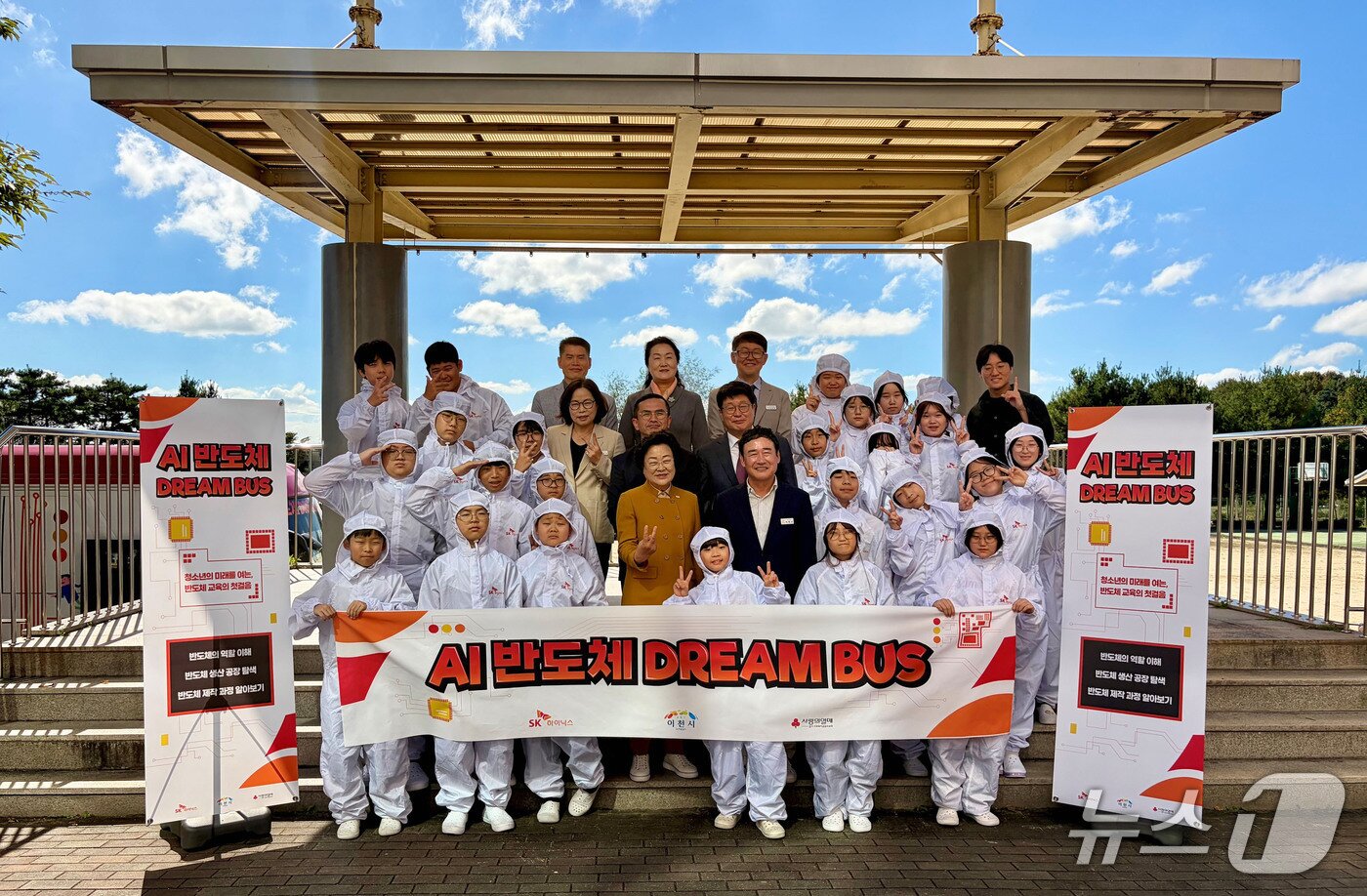 본문 이미지 - 15일 열린 ‘AI 반도체 드림 버스’ 전달식에서 이천사동초 학생들이 방진복을 입고 참석자들과 기념사진을 촬영하고 있다.&#40;SK하이닉스 제공&#41;
