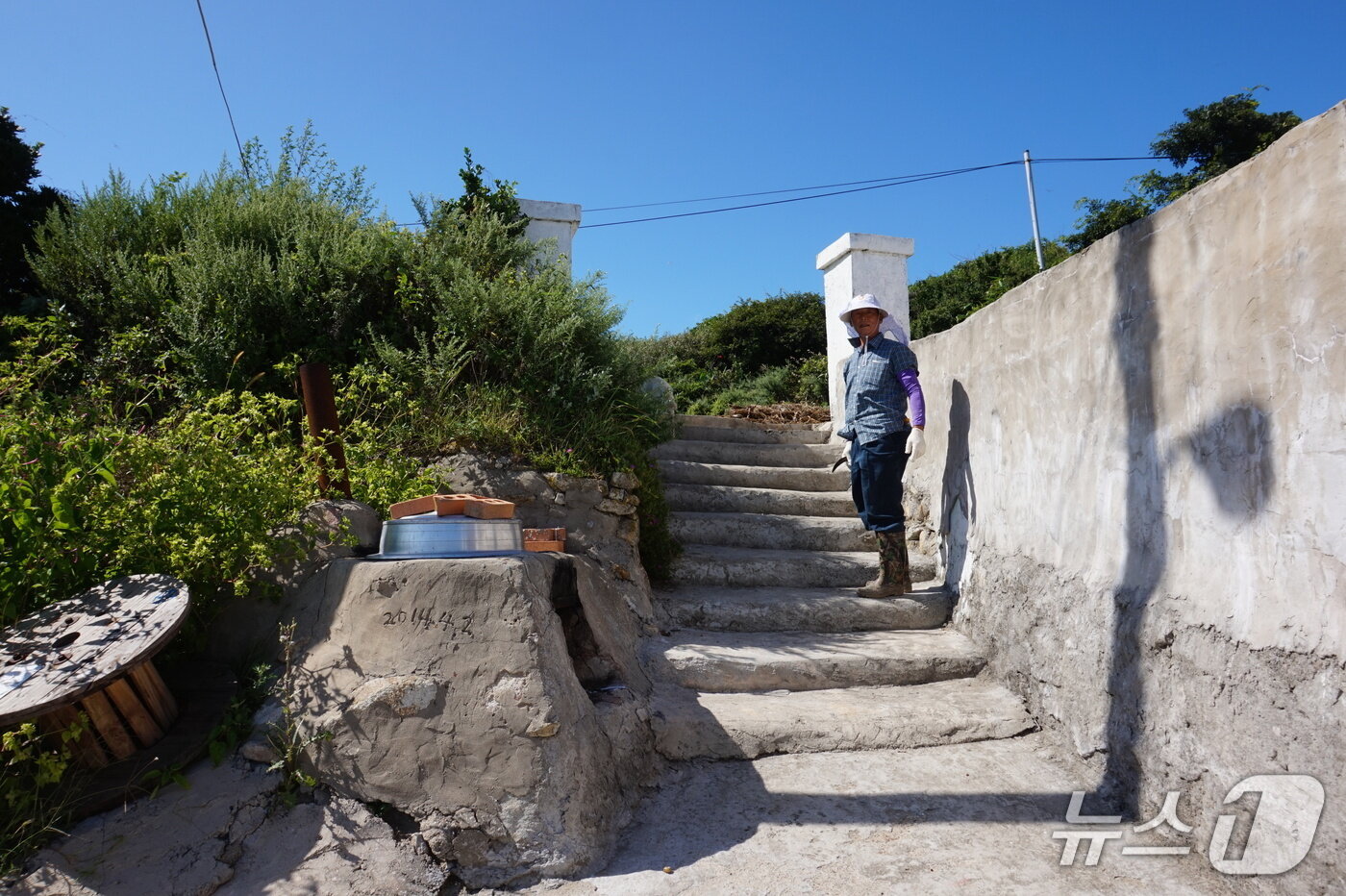 본문 이미지 - 외병도 분교 입구. 마을 이장 김대성 씨가 교문 기둥 앞에서 학교의 역사를 들려주고 있다. 2025.10.18/뉴스1 ⓒ News1 조영석 기자