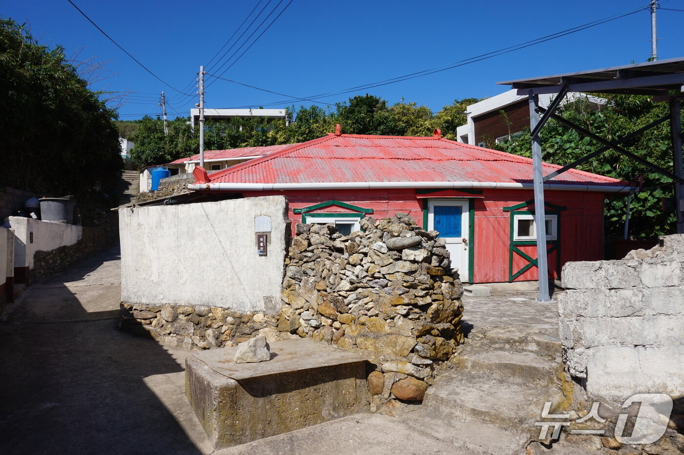 본문 이미지 - 외병도 슬레이트 지붕의 민가. 빨간 지붕 뒤로 여행객을 위한 펜션이 보인다.  2025.10.18/뉴스1 ⓒ News1 조영석 기자